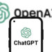 Logotipo de OpenAI detrás de un teléfono móbil con el logo de ChatGPT