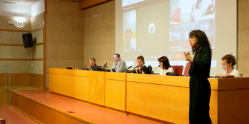Mesa redonda de CIDID 2026, con Juan Pablo Salazar, de CAF, y Javier Monferrer, de la Universitat de València. En primer plano, una intérprete de lengua de signos.