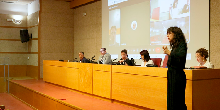 Mesa redonda de CIDID 2026, con Juan Pablo Salazar, de CAF, y Javier Monferrer, de la Universitat de València. En primer plano, una intérprete de lengua de signos.